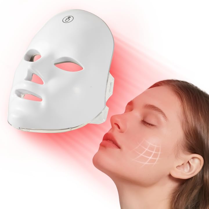 Woman receiving LED face mask treatment with visible red light on a white background